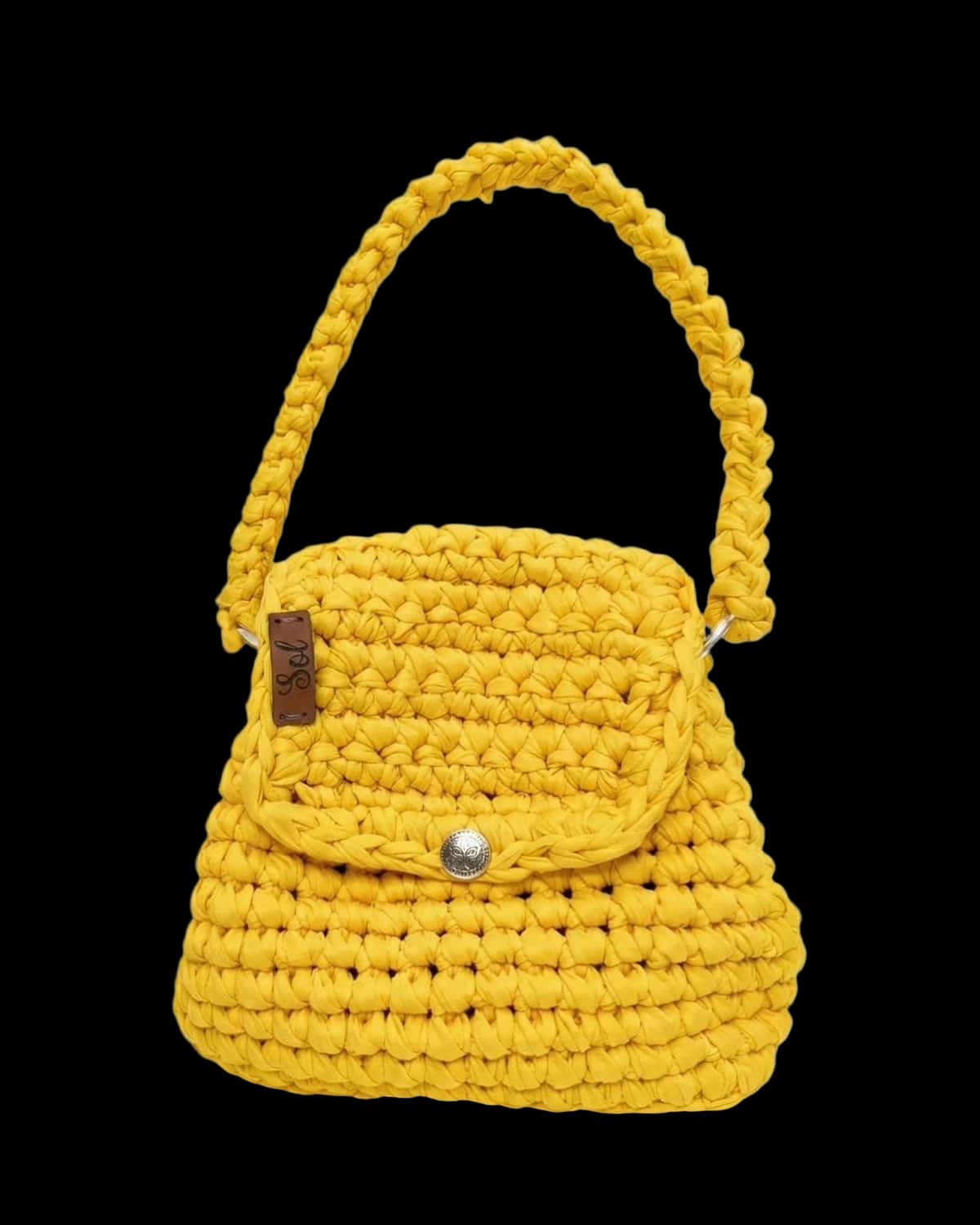 Bolsa infantil amarela em crochê de fio de malha, com aba e alça de mão, foto de catálogo em fundo neutro