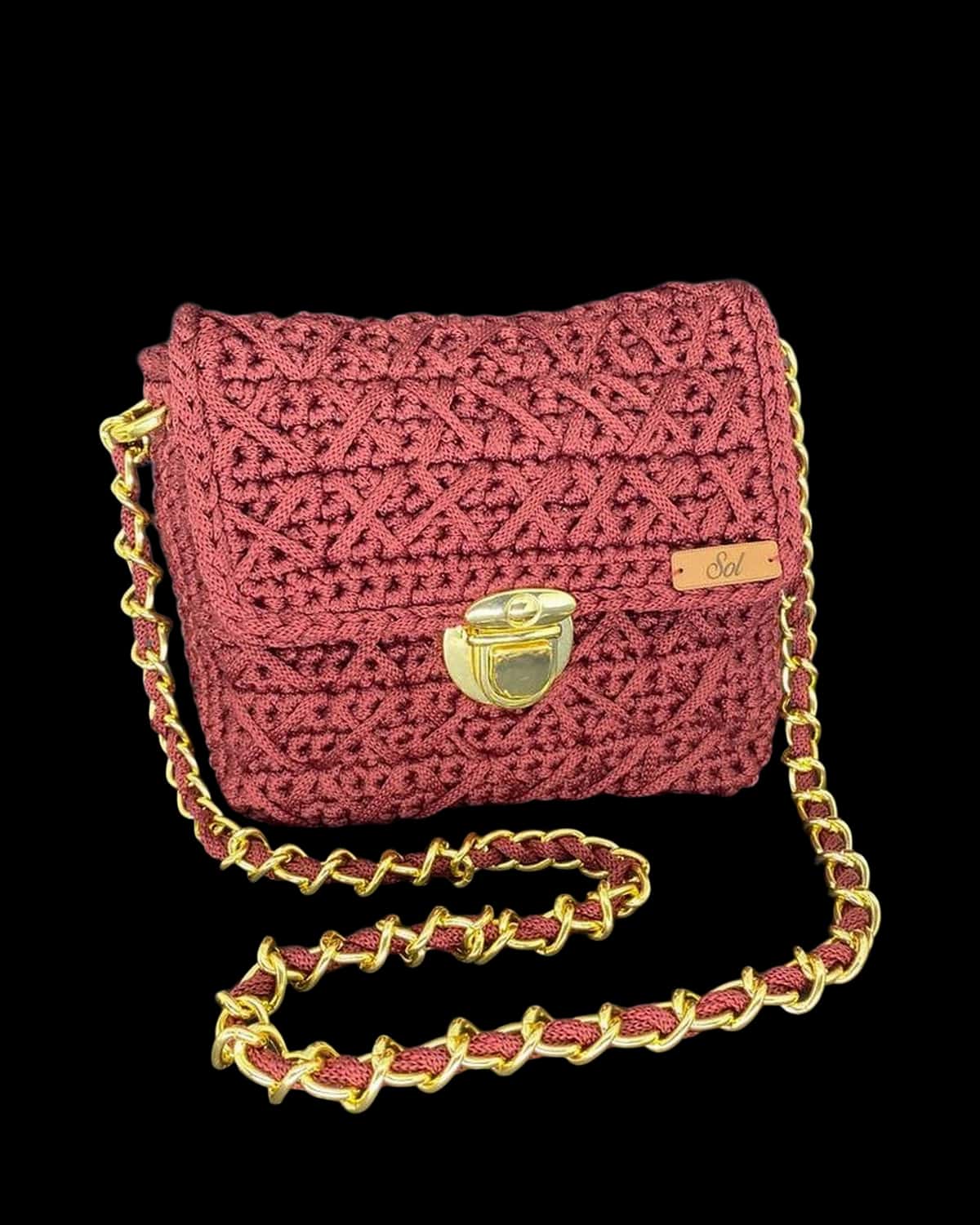 Bolsa Copenhague marsala com aba em crochê trabalhado, fecho dourado e corrente entrelaçada, foto de catálogo em fundo neutro